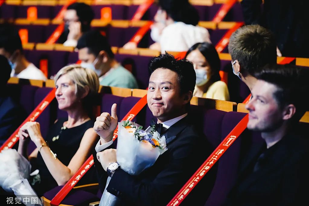 2021年6月19日,第24届上海电影节闭幕式,邓超抱花落座对镜头点赞