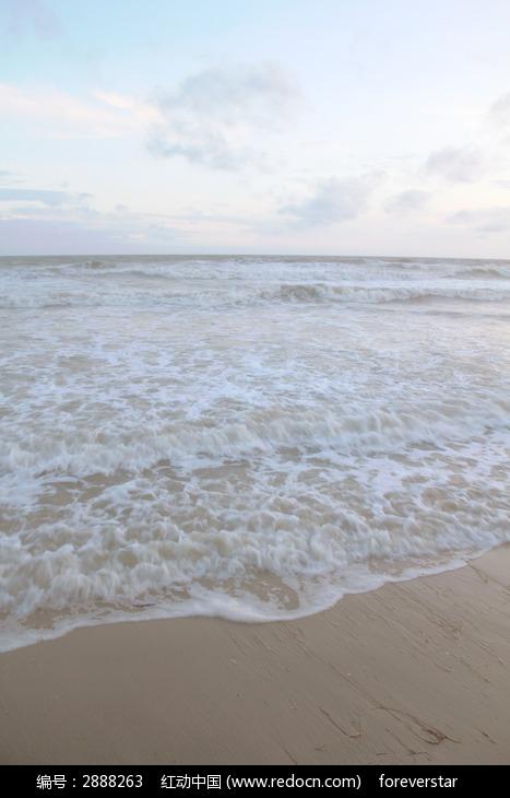 在潮汐的作用下海浪已涌到了沙滩上海浪带着海风吹在人的身上舒服极了